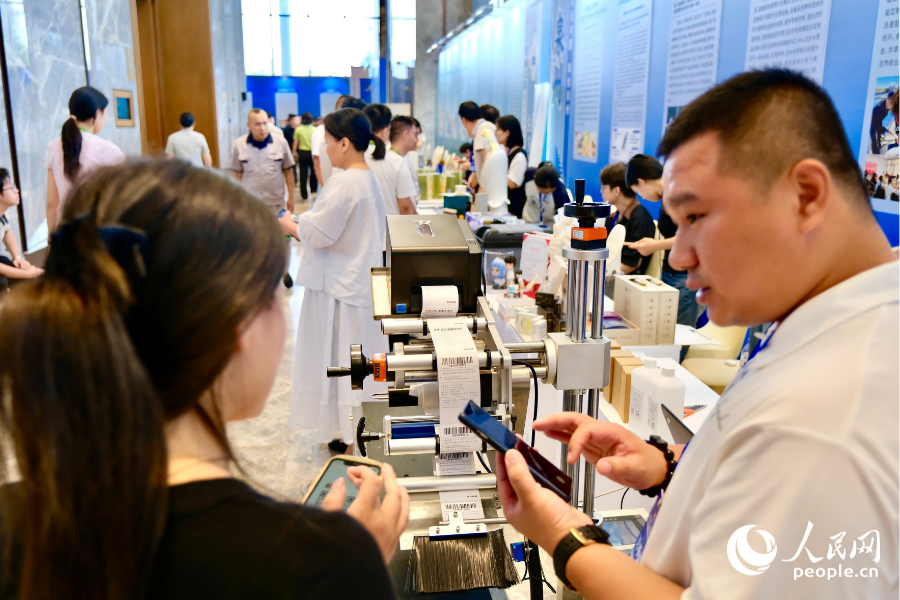 大赛成果交流展区内,参展创业者与参观者达成业务共识,互留联系方式对接合作。人民网 欧阳奕奕摄